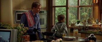 Movie still from “Firewall” (2006), directed by Richard Loncraine – A man and a boy are cooking in a kitchen; Medium shot, Over the shoulder angle