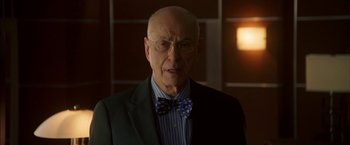 Movie still from “Firewall” (2006), directed by Richard Loncraine – An older man in a suit and bow tie; Close Up shot, Low angle