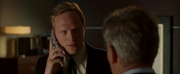 Movie still from “Firewall” (2006), directed by Richard Loncraine – A man talking on a cell phone in front of a mirror; Close Up shot, Over the shoulder angle