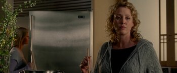 Movie still from “Firewall” (2006), directed by Richard Loncraine – A woman holding a pan in a kitchen; Close Up shot, Over the shoulder angle