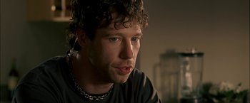 Movie still from “Firewall” (2006), directed by Richard Loncraine – A person wearing a chain necklace; Close Up shot, Over the shoulder angle