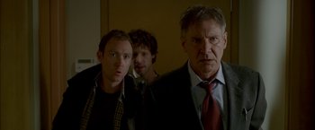 Movie still from “Firewall” (2006), directed by Richard Loncraine – A group of men standing next to each other; Medium shot, Low angle