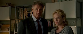 Movie still from “Firewall” (2006), directed by Richard Loncraine – A man and a woman standing next to each other in a room; Medium shot, Low angle