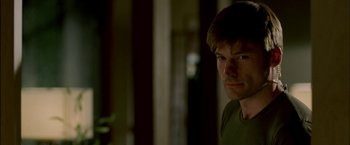 Movie still from “Firewall” (2006), directed by Richard Loncraine – A person in a dark room; Close Up shot, Over the shoulder angle