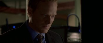 Movie still from “Firewall” (2006), directed by Richard Loncraine – A man in a suit and tie looking to his left; Close Up shot, Over the shoulder angle