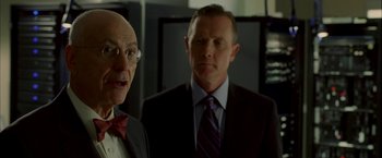 Movie still from “Firewall” (2006), directed by Richard Loncraine – A man in a suit standing next to another man in a suit; Close Up shot, Over the shoulder angle