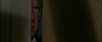 Movie still from “Firewall” (2006), directed by Richard Loncraine – A man's face in a dark room; Close Up shot, Low angle
