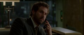 Movie still from “Firewall” (2006), directed by Richard Loncraine – A man talking on a phone while wearing a suit and tie; Close Up shot, Over the shoulder angle