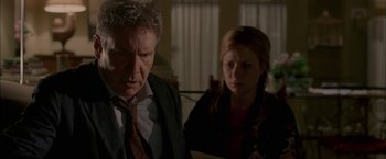 Movie still from “Firewall” (2006), directed by Richard Loncraine – A man and a woman standing next to each other in a room; Close Up shot, Over the shoulder angle