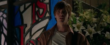 Movie still from “Firewall” (2006), directed by Richard Loncraine – A young man standing in front of a painting; Close Up shot, Over the shoulder angle