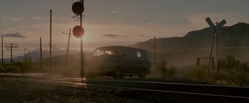 Movie still from “Firewall” (2006), directed by Richard Loncraine – A van driving down a train track near a train station; Extreme Wide shot, Low angle
