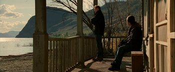 Movie still from “Firewall” (2006), directed by Richard Loncraine – A man standing on top of a wooden deck; Wide shot, High angle