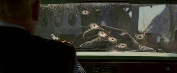 Movie still from “Firewall” (2006), directed by Richard Loncraine – A person looking at bullet holes in a window; Extreme Close Up shot, Over the shoulder angle