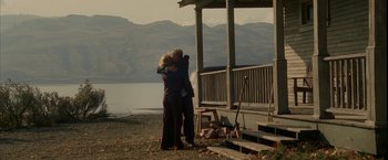 Movie still from “Firewall” (2006), directed by Richard Loncraine – A man and a woman hugging on the beach; Wide shot, Low angle