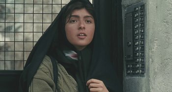 A woman with a black head covering and a black scarf