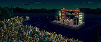 Movie still from “The Simpsons Movie” (2007), directed by David Silverman – A crowd of people standing around a stage with a microphone; Extreme Wide shot, High angle
