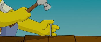 Movie still from “The Simpsons Movie” (2007), directed by David Silverman – A hand holding a hammer and a nail on top of a wooden board; Extreme Close Up shot, Overhead angle