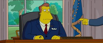 Movie still from “The Simpsons Movie” (2007), directed by David Silverman – A man sitting at a desk wearing a suit and tie; Medium shot, Low angle