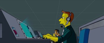 Movie still from “The Simpsons Movie” (2007), directed by David Silverman – A man with a headset is working on a computer; Medium shot, High angle