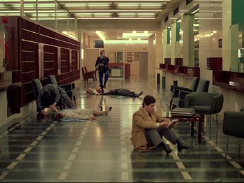 Movie still from “First Name: Carmen” (1983), directed by Jean-Luc Godard – A group of people sitting on the ground in a room; Wide shot, High angle