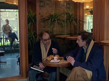 Movie still from “First Name: Carmen” (1983), directed by Jean-Luc Godard – Two men are sitting at a table and having a conversation; Medium shot, High angle