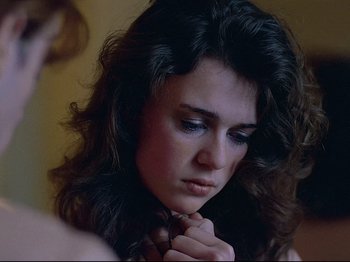 Movie still from “First Name: Carmen” (1983), directed by Jean-Luc Godard – A person holding their hands together; Close Up shot, Over the shoulder angle