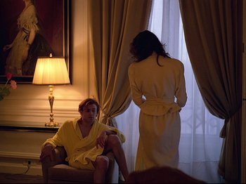 Movie still from “First Name: Carmen” (1983), directed by Jean-Luc Godard – Two women in bathrobes are standing in front of a window; Medium shot, Over the shoulder angle
