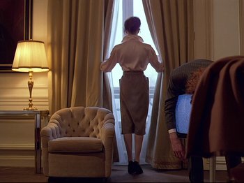Movie still from “First Name: Carmen” (1983), directed by Jean-Luc Godard – A woman standing in front of a window looking outside; Medium shot, Low angle