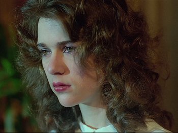 Movie still from “First Name: Carmen” (1983), directed by Jean-Luc Godard – A person with curly hair; Close Up shot, Low angle