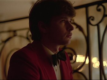 Movie still from “First Name: Carmen” (1983), directed by Jean-Luc Godard – A man in a red jacket with a bow tie; Close Up shot, Low angle