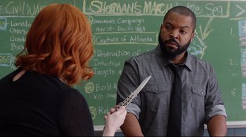 A man holding a knife in front of a woman