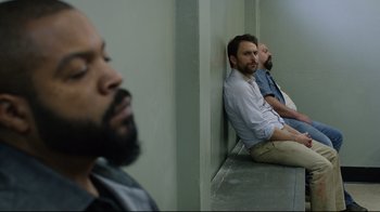 Two men sitting on the ground in a room