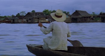Movie still from “Fitzcarraldo” (1982), directed by Werner Herzog – A person in a boat on a body of water; Wide shot, High angle