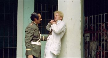Movie still from “Fitzcarraldo” (1982), directed by Werner Herzog – A man in a white suit and a man in a military uniform; Medium shot, Low angle