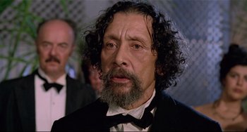 Movie still from “Fitzcarraldo” (1982), directed by Werner Herzog – A man with long hair and a beard wearing a tuxedo; Close Up shot, Low angle