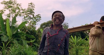 Movie still from “Fitzcarraldo” (1982), directed by Werner Herzog – An older man wearing a hat standing in the grass; Medium shot, Low angle