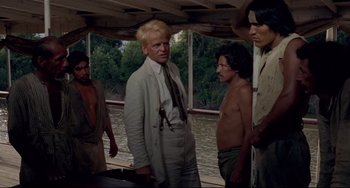 Movie still from “Fitzcarraldo” (1982), directed by Werner Herzog – A group of men standing next to each other on top of a boat; Medium shot, Over the shoulder angle