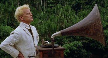 Movie still from “Fitzcarraldo” (1982), directed by Werner Herzog – An older man is listening to an old fashioned record player; Medium shot, Low angle