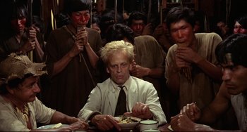 Movie still from “Fitzcarraldo” (1982), directed by Werner Herzog – A man sitting at a table with a plate of food in front of him; Medium shot, High angle