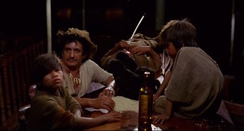 Movie still from “Fitzcarraldo” (1982), directed by Werner Herzog – A group of people sitting around a wooden table; Medium shot, High angle