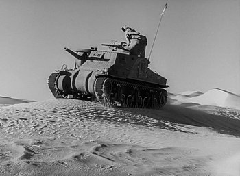 Movie still from “Five Graves to Cairo” (1943), directed by Billy Wilder – An old photo of a tank on the sand dunes; Extreme Wide shot, High angle