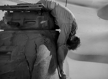 Movie still from “Five Graves to Cairo” (1943), directed by Billy Wilder – A man leaning on the side of a building; Wide shot, Low angle