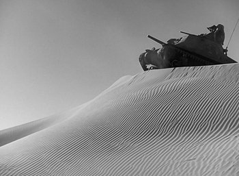 Movie still from “Five Graves to Cairo” (1943), directed by Billy Wilder – A black - and - white photo of a tank on top of a sand dune; Extreme Wide shot, Low angle