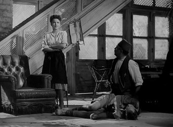 Movie still from “Five Graves to Cairo” (1943), directed by Billy Wilder – A man and a woman are sitting on the floor; Wide shot, High angle