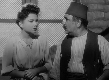 Movie still from “Five Graves to Cairo” (1943), directed by Billy Wilder – An old photo of a man and a woman talking; Medium shot, Over the shoulder angle