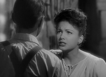 Movie still from “Five Graves to Cairo” (1943), directed by Billy Wilder – A woman is talking to a man in a black and white photo; Close Up shot, Over the shoulder angle