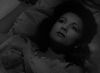 Movie still from “Five Graves to Cairo” (1943), directed by Billy Wilder – A black - and - white photo of a woman laying in a bed; Close Up shot, High angle