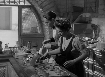 Movie still from “Five Graves to Cairo” (1943), directed by Billy Wilder – Two women are preparing tea in an old - fashioned kitchen; Medium shot, Low angle