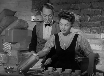Movie still from “Five Graves to Cairo” (1943), directed by Billy Wilder – A man and a woman are pouring tea into cups; Medium shot, High angle
