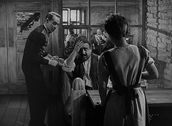 Movie still from “Five Graves to Cairo” (1943), directed by Billy Wilder – An old black and white photo of a group of people; Medium shot, Over the shoulder angle